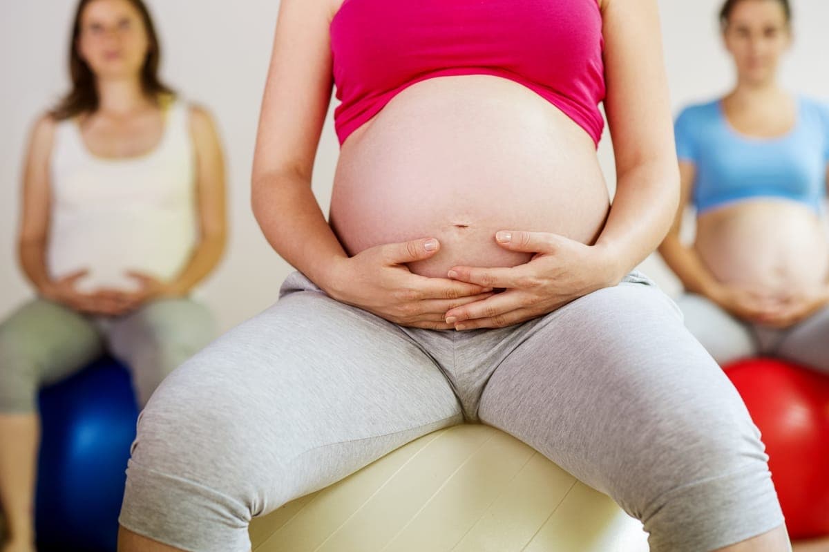 Woman's hands gently pressing along the midline of her abdomen to check for abdominal separation