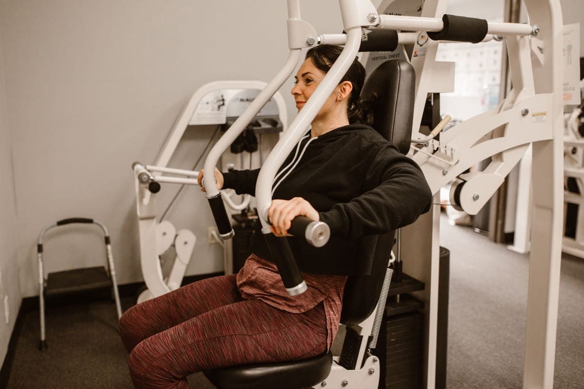 Woman doing strength training at a gym, representing exercise options for managing PCOS