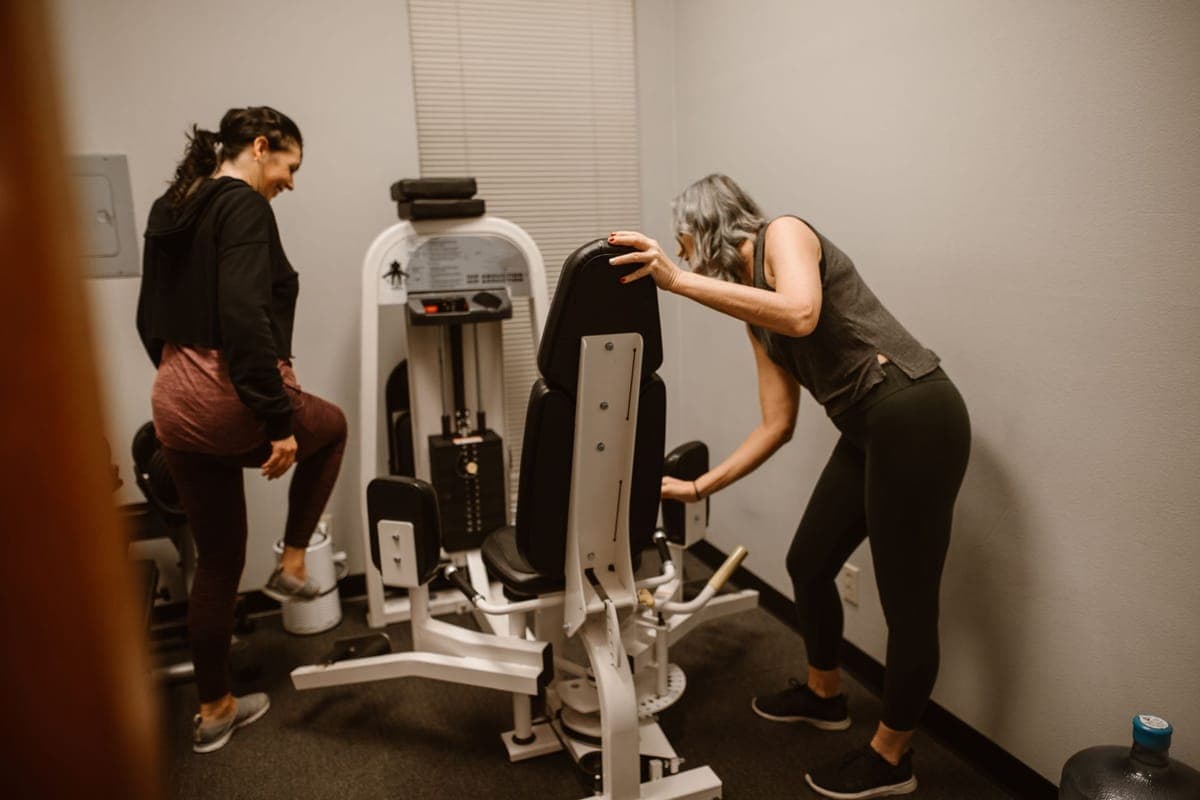 Woman in activewear reviewing a structured workout plan on her phone, representing evidence-based PCOS exercise programming