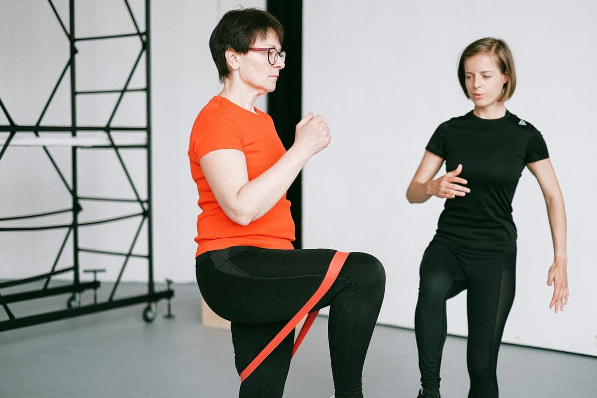 Woman performing resistance training with dumbbells in a gym setting, representing strength training during perimenopause