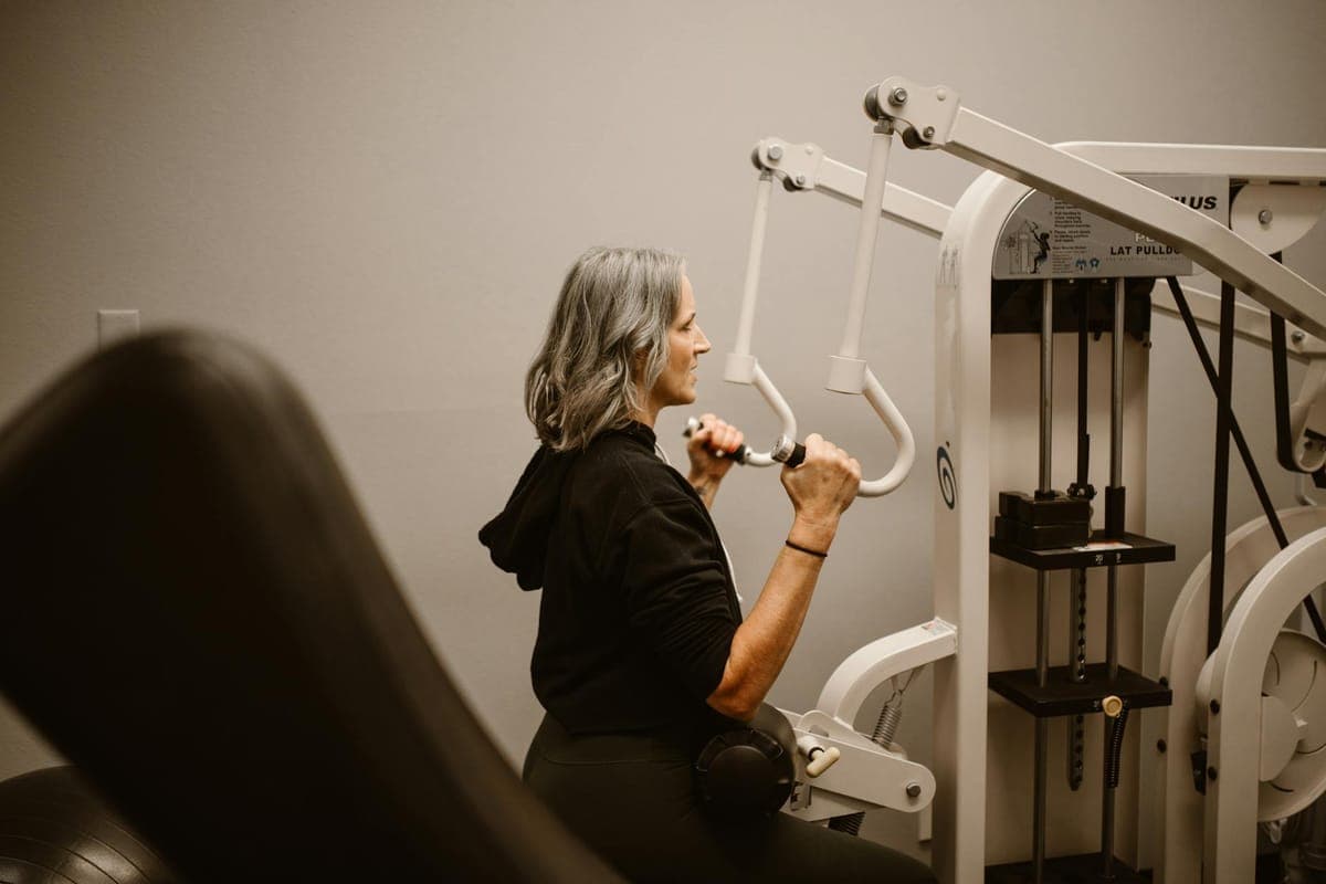 Woman performing strength training exercise with dumbbells in home setting