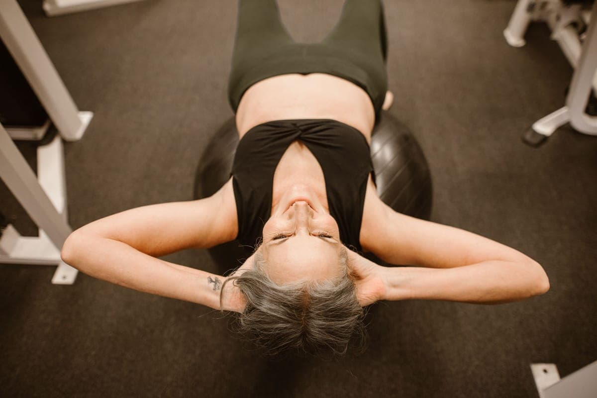 Woman lifting weights in a bright gym, representing strength training through menopause