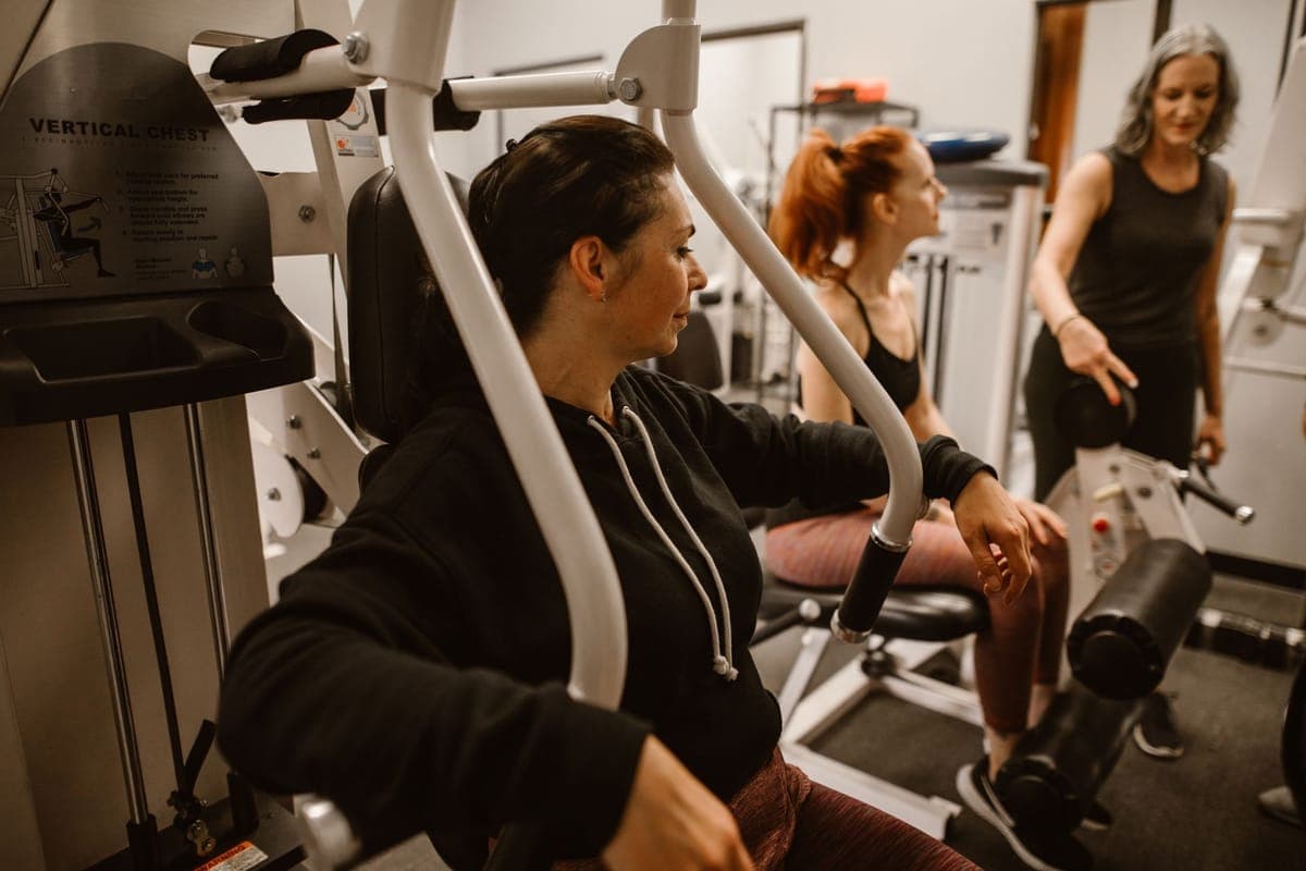 Woman strength training with protein-rich foods including Greek yogurt, eggs and salmon